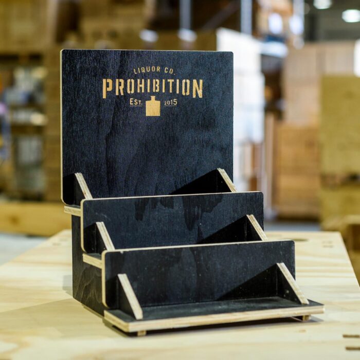 Prohibition Liquor Co router cut, tiered bar display with logo laser etched out of black laminated ply