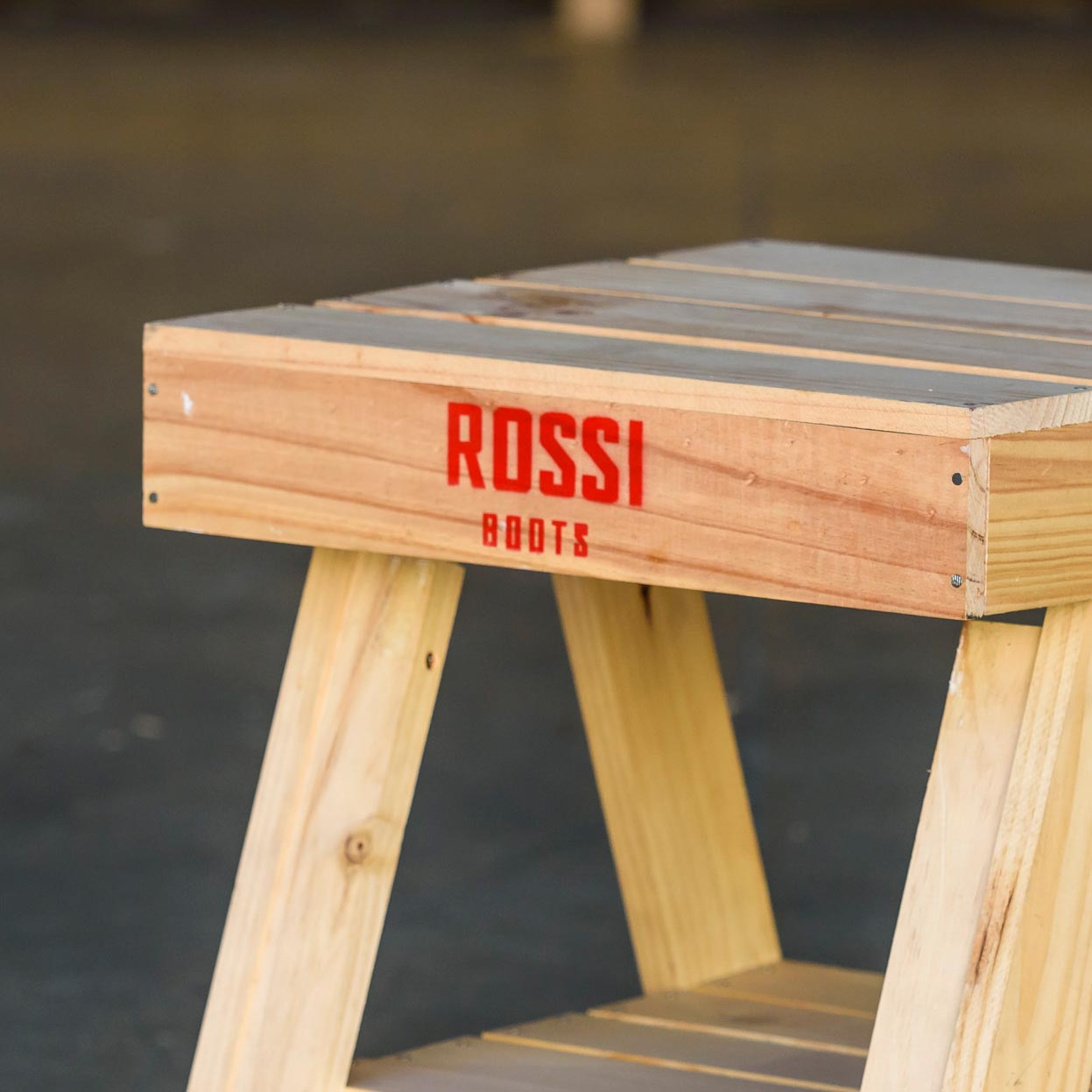 Wooden stool with custom Rossi Boots stamp, close-up